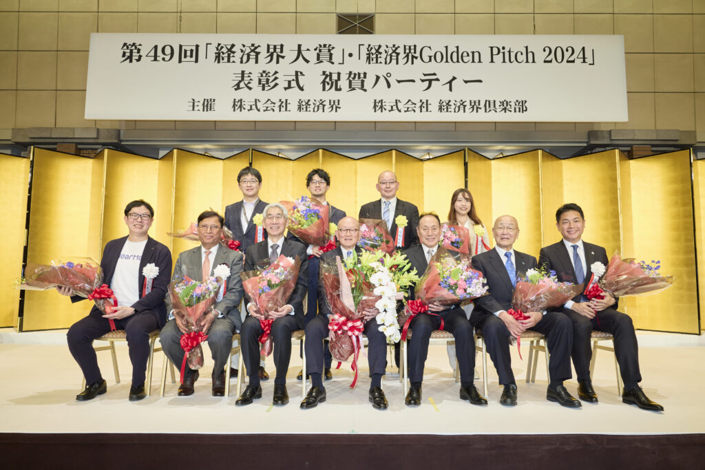 第49回経済界大賞・経済界GoldenPitch2024の受賞者の皆様(前列左から、髙原幸一郎 NearMe社長、 ジュネジャ レカ ラジュ 亀田製菓会長CEO、森田隆之 NEC社長兼CEO、岡藤正広 伊藤忠商事会長CEO、芳井敬一 大和ハウス工業社長CEO、鈴木与平 鈴与会長、岡田光信 アストロスケールホールディングス社長兼CEO。後列左から、進藤寛也 エアシェア代表取締役CEO、藪 和弥 MOSH Co-Founder / CEO、大槻知史 きづなろ代表取締役CEO、山田真愛 My Fit代表取締役)