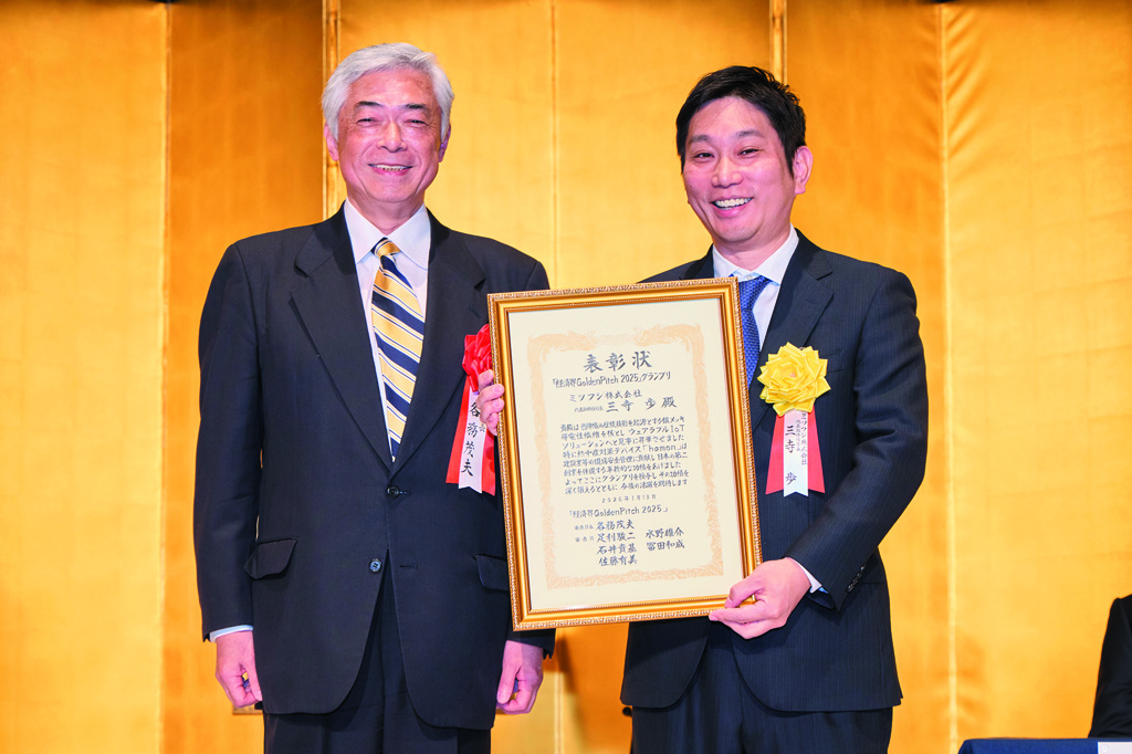 「経済界Golden Pitch 2025」審査員長の各務茂夫・開志専門職大学学長・東京大学名誉教授（左）からグランプリ受賞の三寺歩・ミツフジ社長に表彰状が授与された