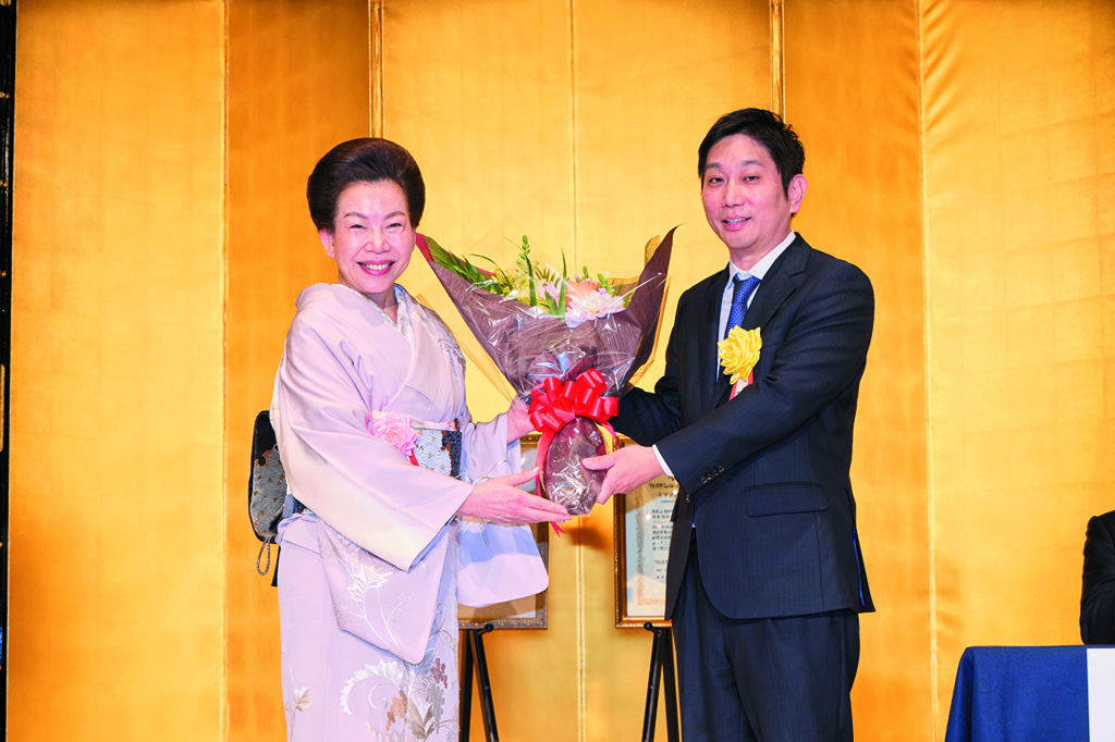 三寺歩・ミツフジ社長（右）に花束を贈呈する佐藤有美・経済界会長