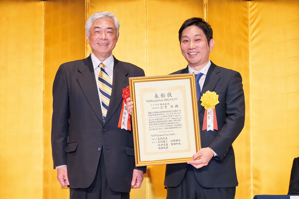 「経済界Golden Pitch 2025」審査員長の各務茂夫・開志専門職大学学長・東京大学名誉教授（左）からグランプリ受賞の三寺歩・ミツフジ社長に表彰状が授与された
