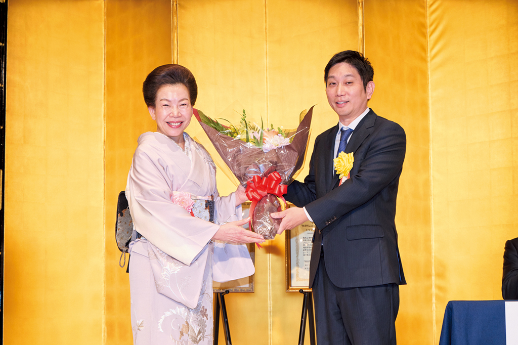 三寺歩・ミツフジ社長（右）に花束を贈呈する佐藤有美・経済界会長